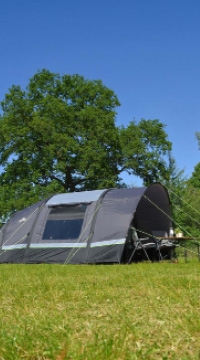 Tienda túnel gris en parcela de camping verde