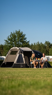 Camping en tienda con pareja sentada